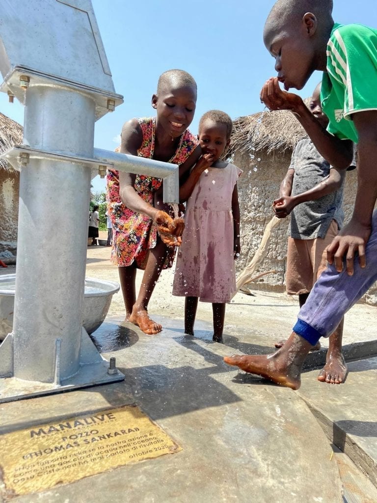 NFT: cosa sono e come possono essere utilizzati per finanziare progetti umanitari, NFT: cosa sono e qual è lo scopo del loro utilizzo, L'associazione Manalive e la fine della costruzione del pozzo in Togo, bambini che bevono acqua pulita