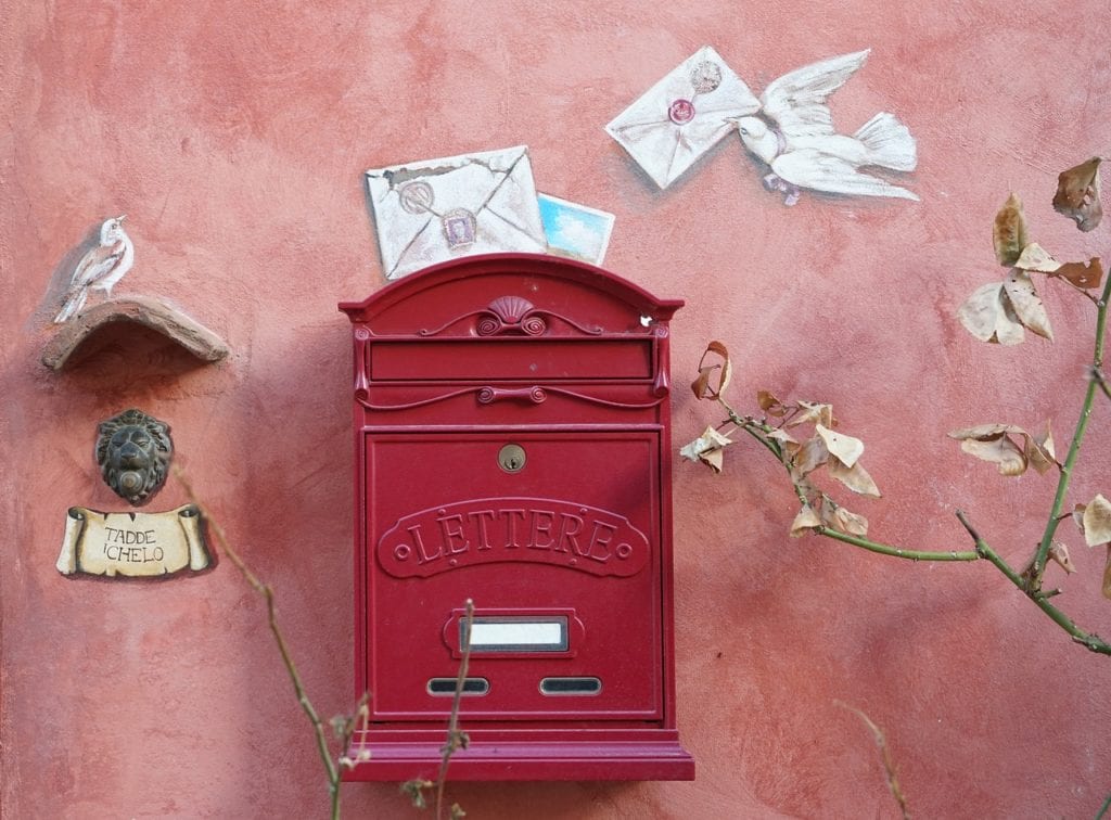 Buste e corrispondenza cartacea: perché sono importanti per le piccole imprese. La foto ritrae una cassetta delle lettere rossa in primo piano