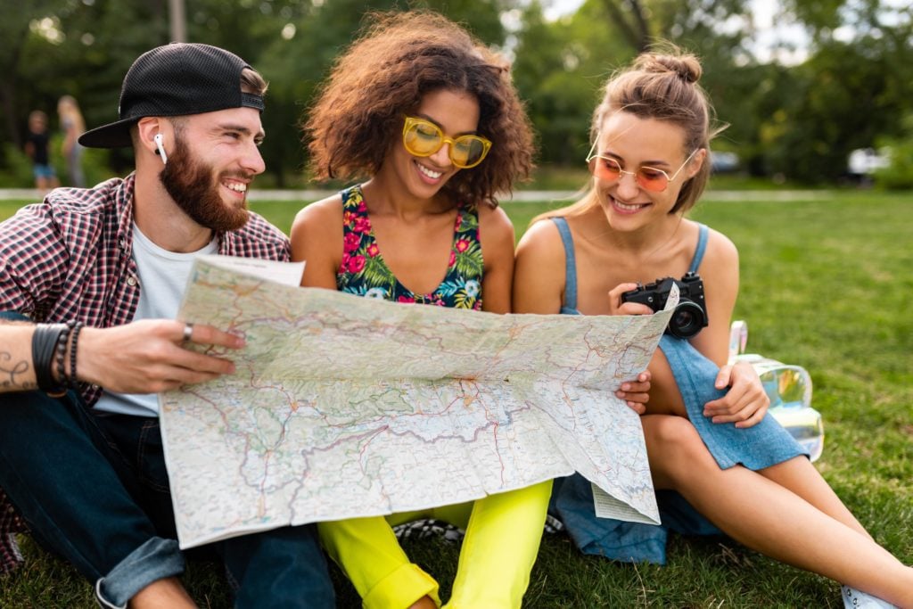 Nasce un nuovo modo per contrastare il turismo di massa. È il tour per intenditori ed è già amato da tutti. In foto tre giovani turisti con cartina in mano