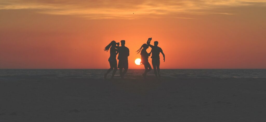 ragazzi che ballano insieme al tramonto