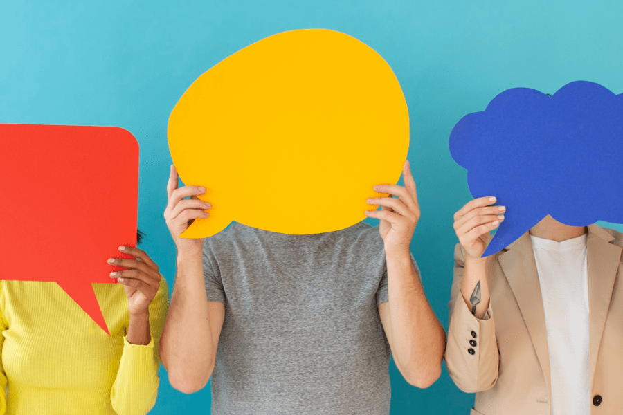 tre persone che si coprono il volto con tre cartoncini di forme e colori diversi - Conflitti sociali: siamo certi di comprendere le parole dell’altro?