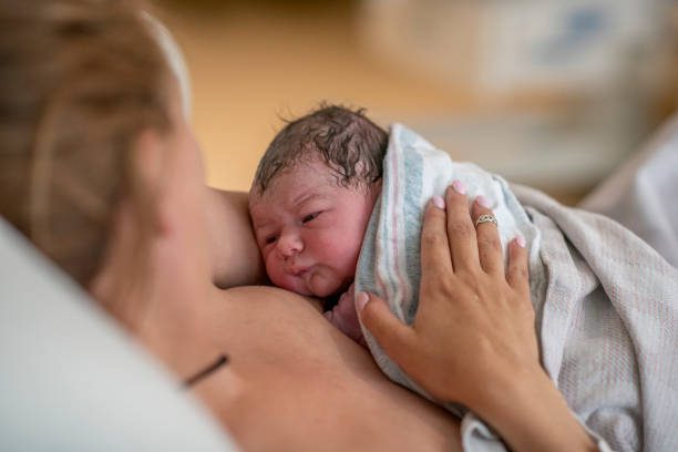 Una mamma tiene in braccio il suo piccolo appena nato
