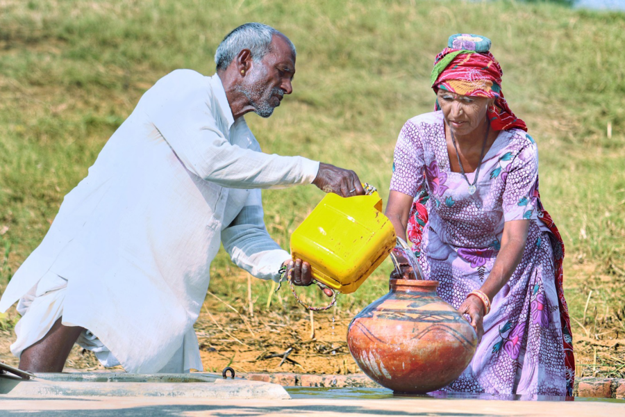 Uomo che versa acqua in un'anfora retta da una donna-La gestione dell'acqua nei Paesi in via di Sviluppo