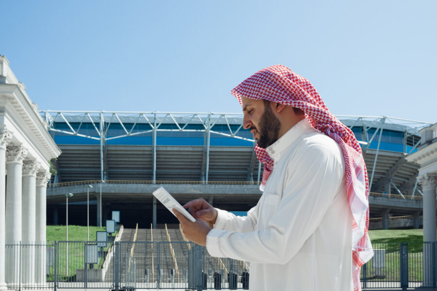Arabia Saudita: uomo arabo dirige nuovi affari tramite telefono fuori ad uno stadio di calcio