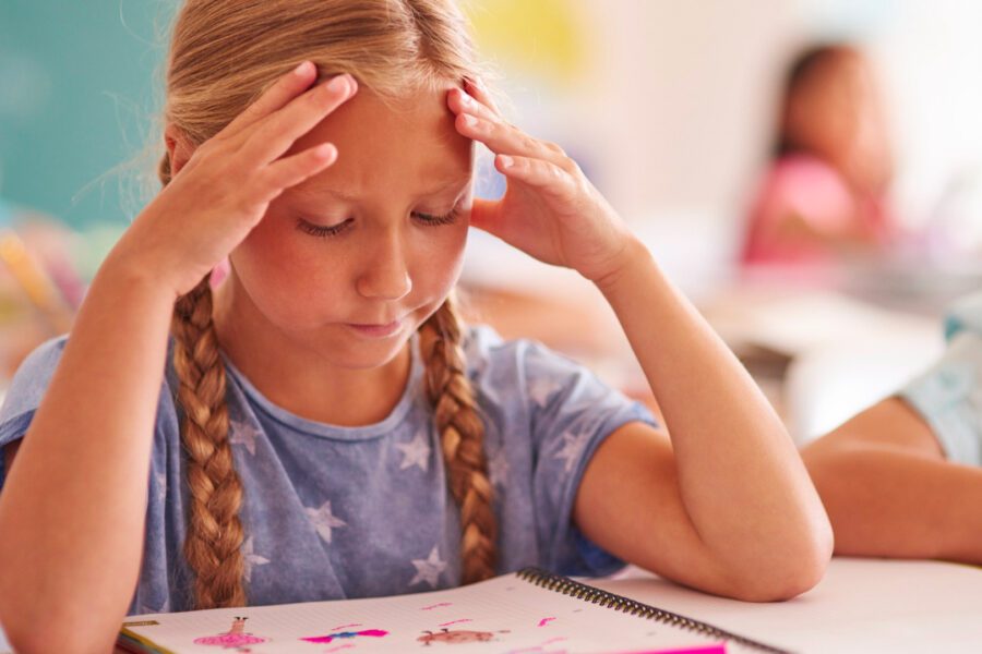 Bambina con mani sulla testa che fatica a concentrarsi-L’ADHD, conoscere il disturbo da deficit di attenzione e iperattività
