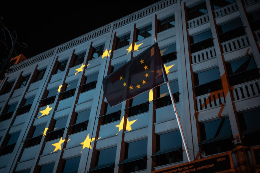 La politica estera e di sicurezza comune (PESC), l’attuale posizione e il ruolo storico dell’Unione Europea nella questione israelo-palestinese. Bandiera europea su edificio bianco, di notte.