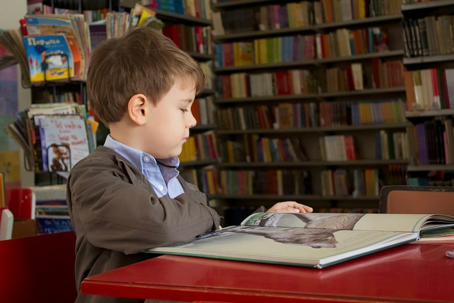 Un bambino legge un libro su un tavolino in una libreria