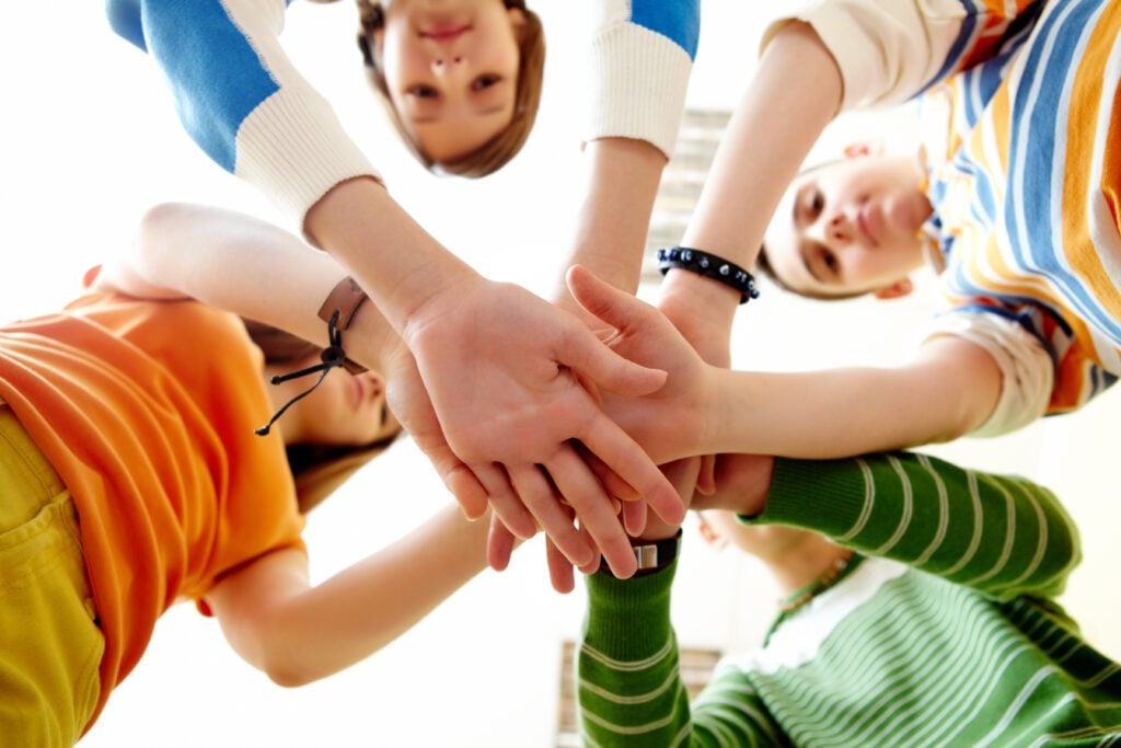 Ragazzi che si tengono per mano, uniti per combattere la violenza di genere.