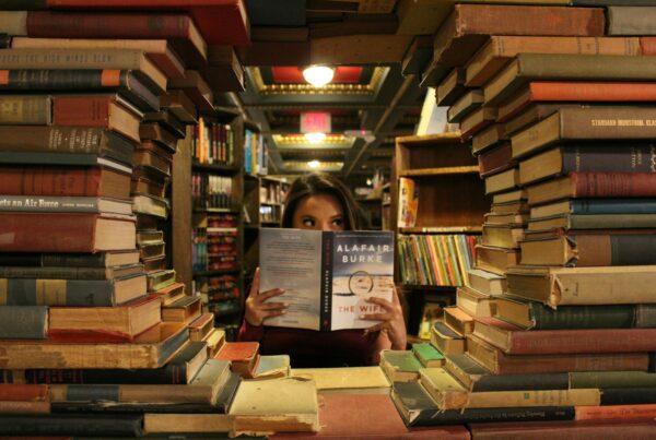 Libri da leggere- donna legge un libro dietro una cornice di libri.jpg