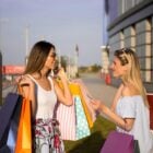 Due donne parlano felici mentre fanno acquisti durante i saldi estivi