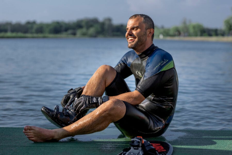 Sport inclusivo: Daniele Cassioli si toglie uno scarpone da sci.