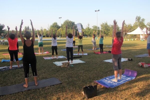 Attività fisica: persone intente a fare pilates in un parco.